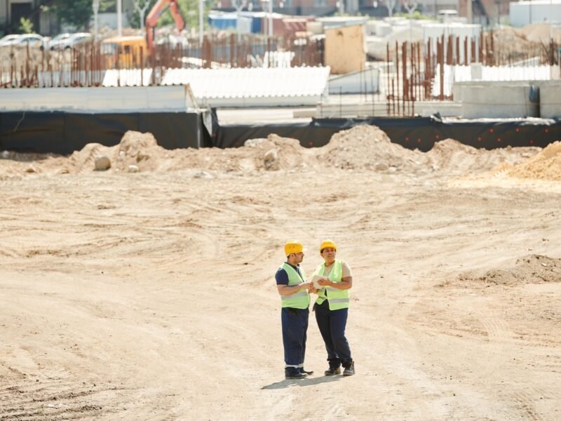 Workers in hard hats standing on a construction site