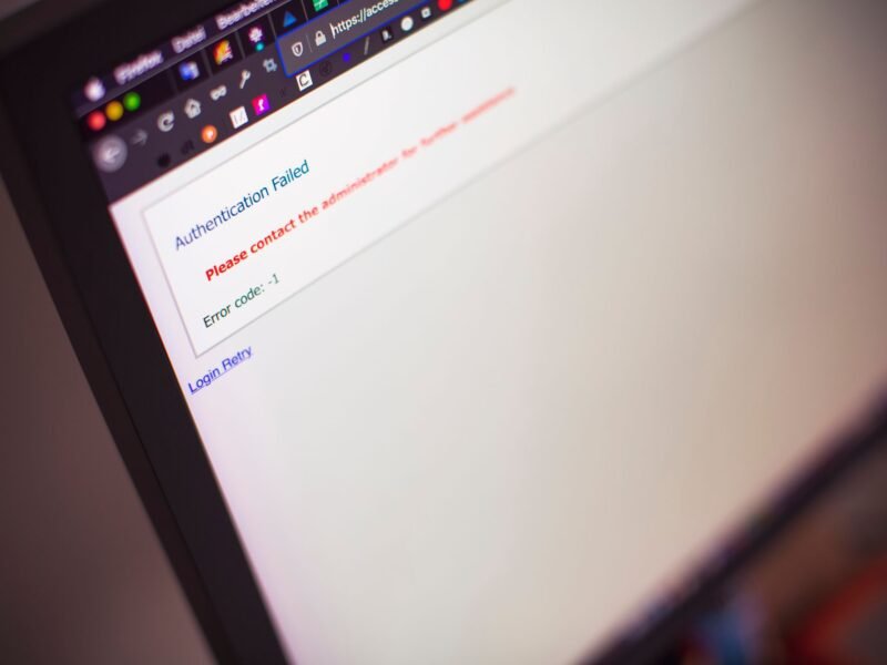 A laptop screen in close-up, code and interface reflected in the display