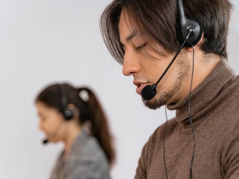 A man wearing a headset at a customer support desk